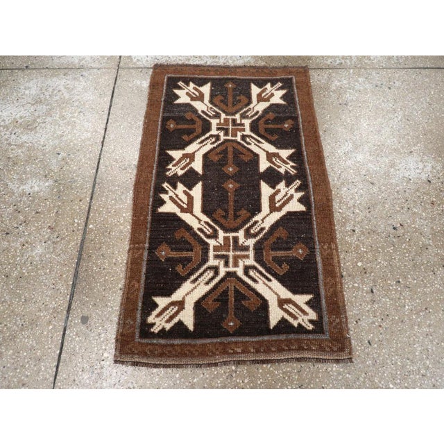 This Mid-20th century Turkish Anatolian rug, measuring 1' 10" x 3' 2", features a bold tribal composition with strong...