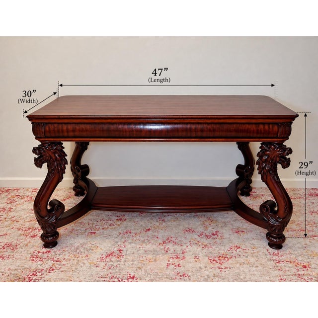 A commanding American library table in the manner of R.J. Horner. Four S-scroll legs rise into deeply carved, open-mouthed...