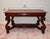 A commanding American library table in the manner of R.J. Horner. Four S-scroll legs rise into deeply carved, open-mouthed...