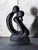 This modern minimalist sculpture, made in Portugal features a matte black finish and abstractly depicts a couple in an...