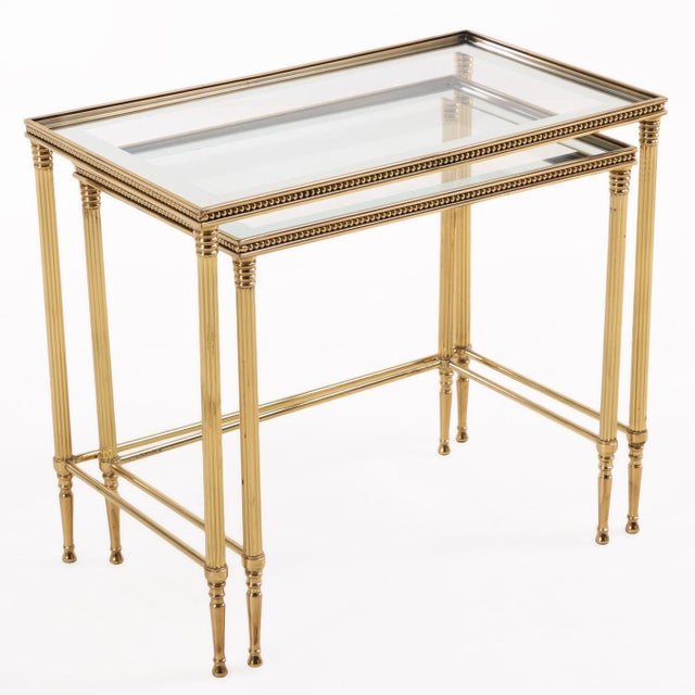 Pair of Italian brass nesting tables in the Hollywood Regency style, inspired by the work of Maison Baguès. The tables...