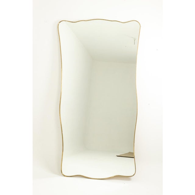Mirror with a gilded brass frame. Italian piece from the 1980s or 1990s, in the style of Gio Ponti. Design. This piece is...