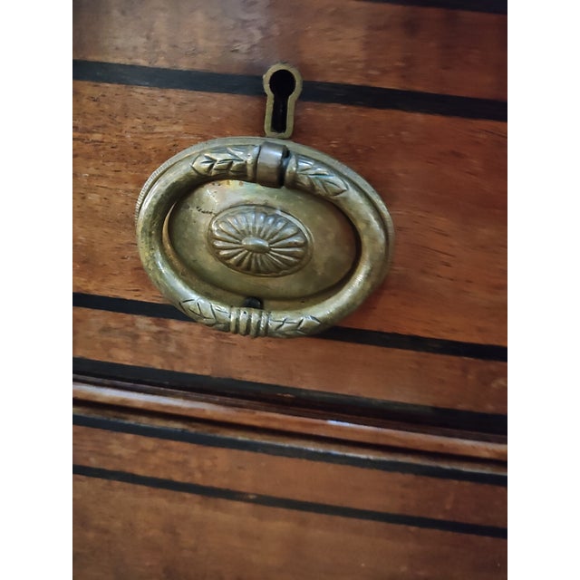 An elegant early 19th century Italian Neoclassical walnut chest of drawers, dating to circa 1820, distinguished by...