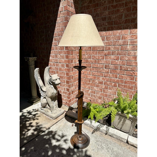 A vintage ratcheting floor lamp in the style of Frances Elkins, featuring a solid, turned base and an adjustable vertical...
