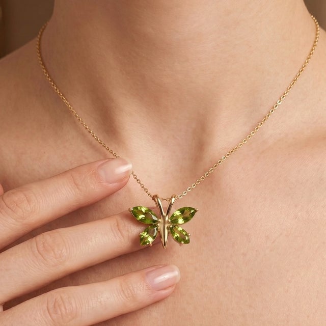 The wings are beautifully brought to life by four brilliant, marquise and pear-cut natural peridot gemstones. The lush,...