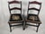 A charming pair of vintage dark wood side chairs featuring beautifully detailed floral needlepoint seats, gracefully...