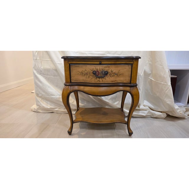 Pair of French Provincial style nightstands by Butler Specialty Co. Each has handpainted floral decor on the front, top...