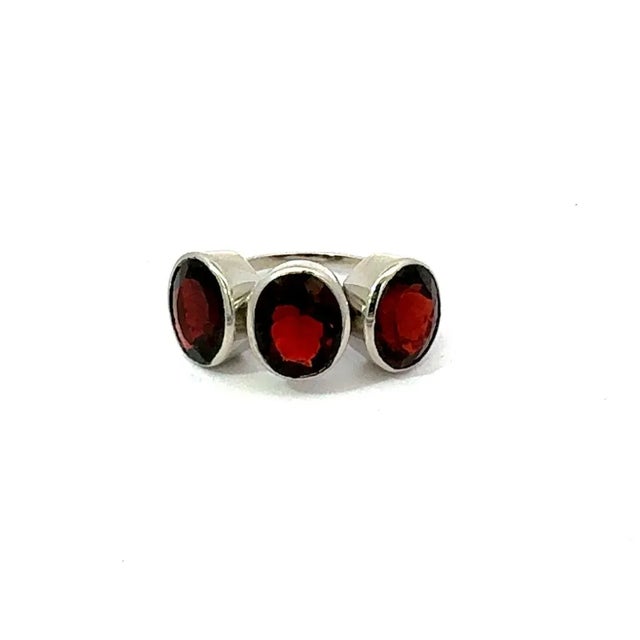 This 925 solid silver three stone garnet ring is designed for unisex appeal, featuring three oval-shaped garnets measuring...