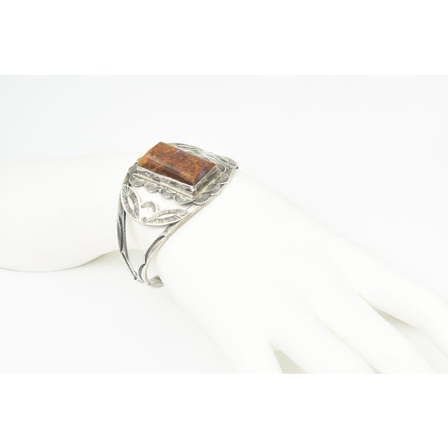 Southwestern Native American style cuff bracelet featuring a rectangular moss agate cabochon set in a decorative silver...