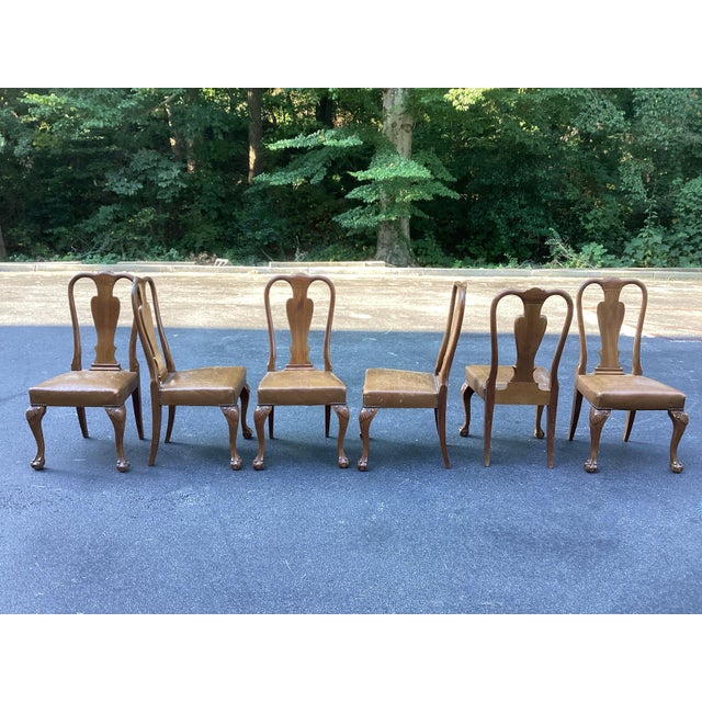 A handsome set of six vintage Queen Anne-style dining chairs featuring beautifully shaped solid wood frames and richly...