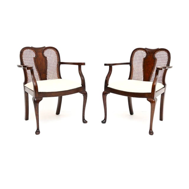 A lovely pair of antique Edwardian walnut cane back armchairs. They were made in England and date from around 1900-1920....