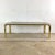 This vintage coffee table from the 1970s offers a sleek expression of retro elegance, blending a polished brass frame with...
