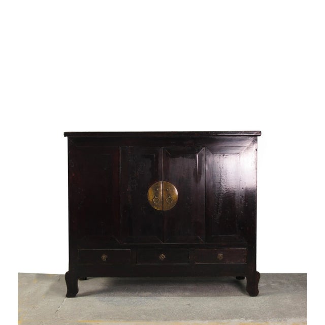 This dark brown Chinese antique cabinet stands 56.5 inches tall and features traditional Chinese design. The cabinet is...