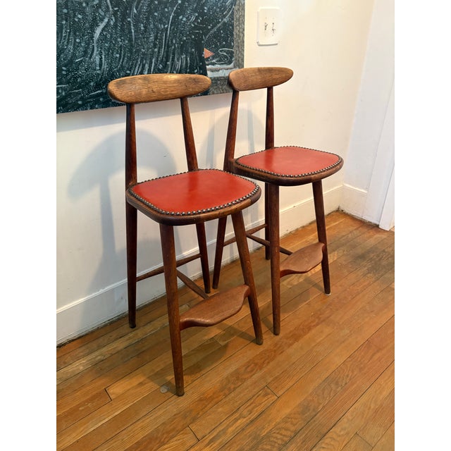 Mid-century counter stools are an iconic Danish design by Vilhelm Wohlert for Stolefabriken Odense, featuring a warm wood...