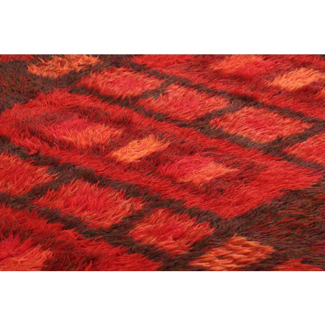 Hand-knotted in lush, high-pile wool in Sweden circa 1960-1970, this 4x6 vintage Swedish Rya rug is a bold new addition to...
