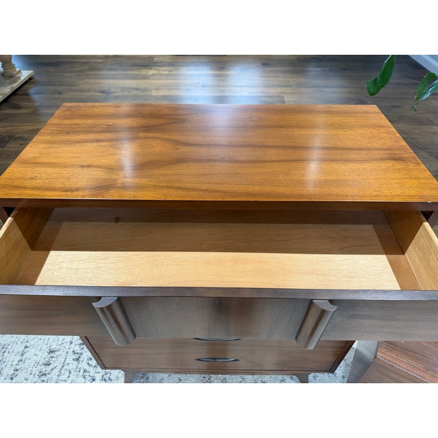 A beautifully crafted mid-century modern walnut tall chest, featuring clean architectural lines and a striking sculptural...