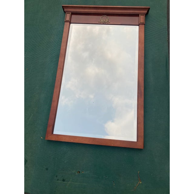 1996 Bombay Company rectangular beveled mirror. Has laurel leaf wreath metal appliqué in center with rectangular metal...