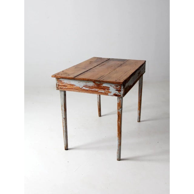 This is an antique painted wood side table. The primitive table features aged gray-blue paint with a natural wood table...