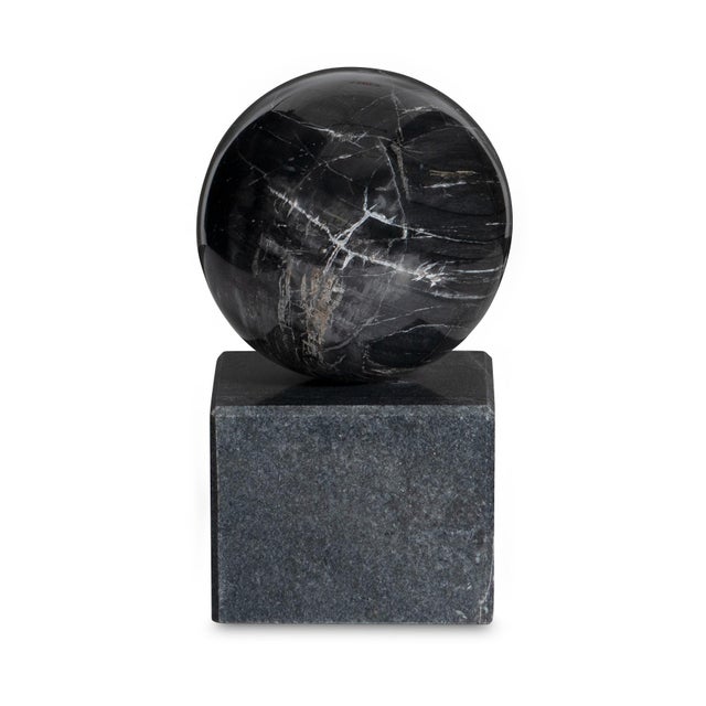 Evoking the quiet strength of elemental form, this marble orb rests with serene balance atop a geometric plinth. The piece...