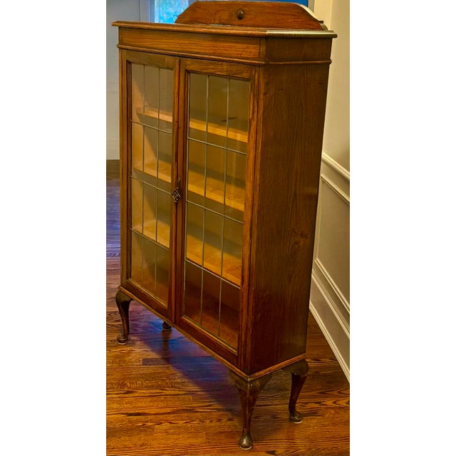 Antique Edwardian /Arts and Crafts oak bookcase dating to approximately 1910–1920; featuring fully intact leaded-glass...