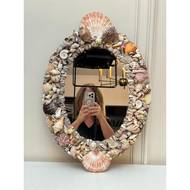 The soft oval shape as well as the varied pastel to earthtoned colors exude throughout this Palm Regency Style mirror. The...