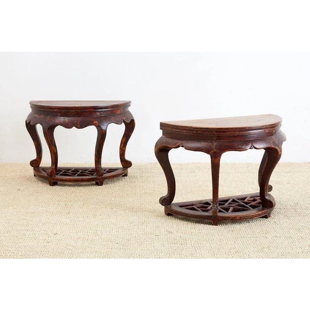 Handsome pair of Chinese hardwood carved side tables or end tables having a demilune form. Each four legged table is...