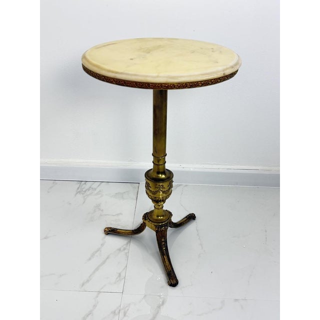 Italian brass coffee table with marble top, 1950s Good condition, as shown in the photographs. Height 64 cm, diameter 40 cm.
