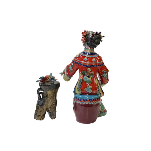 This is a Chinese decorative ceramic pottery figure of an ancient Qing style dressing lady with fine precise fingers and a...