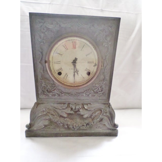 This is a Antique Early and Rare Chauncey Jerome Pewter Front on Wood Body Shelf Clock with an Ornate Design of Garlands...