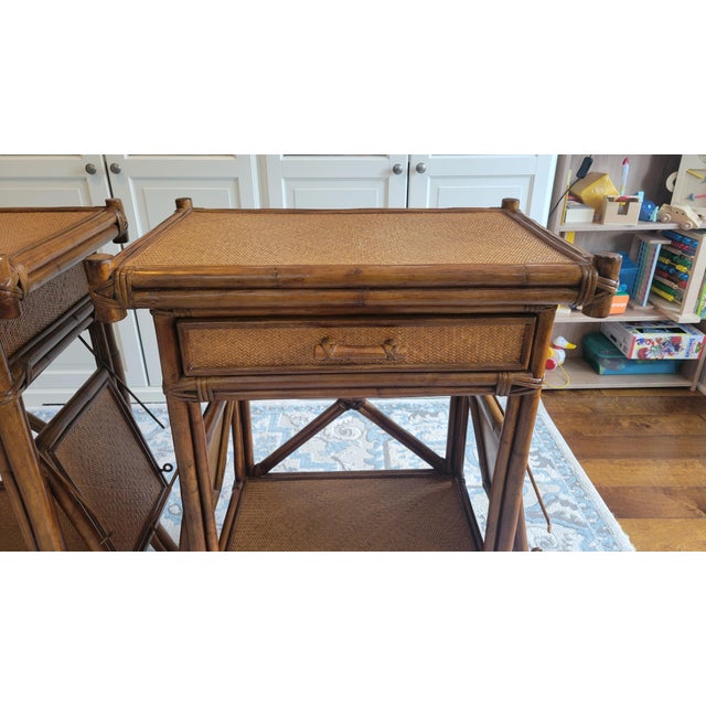 Beautiful vintage pair of British Colonial-style rattan side tables, featuring warm amber wood tones, woven cane/rattan...
