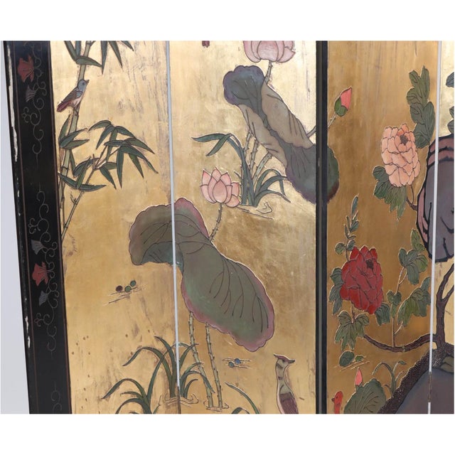 A four-panel double-sided Chinese Coromandel-style folding screen room divider with a black lacquered frame bordered by...
