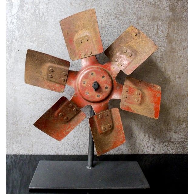 Antique 1920s re-purposed industrial farm equipment implement on stand. Rusty red metal wheel/blade mounted on iron base....