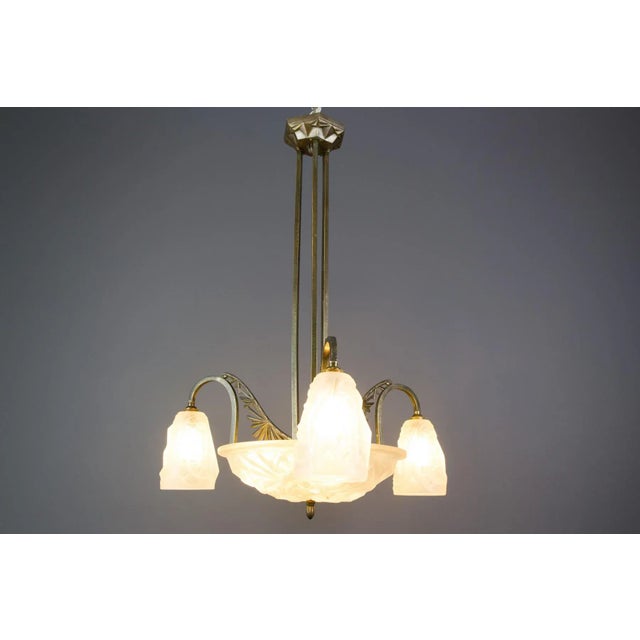 This beautiful French Art Deco six-light chandelier features white frosted molded-pressed glass shades with stylized...