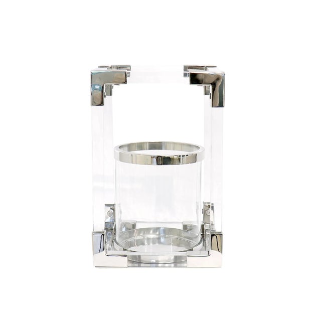 The Soren lantern features a sleek geometric design crafted from lucite and polished chrome, blending modern materials...