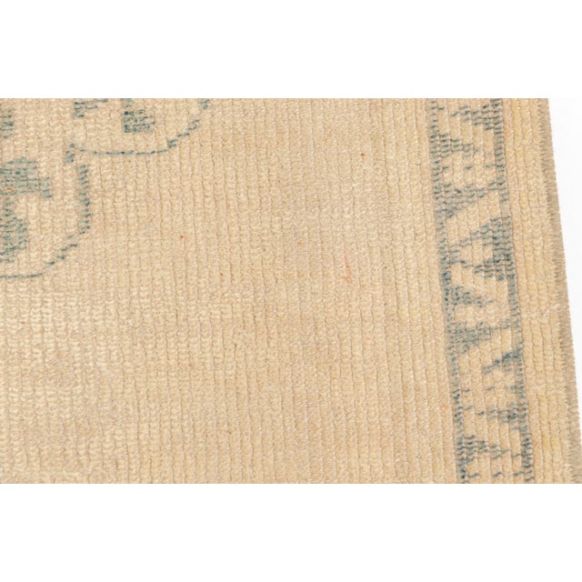 This is a vintage Turkish Oushak rug from the Mid 20th Century. The piece was hand-knotted.