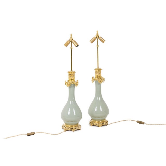 Pair of celadon porcelain lamps, solid color. Gilded and chiseled bronze, wavy at the top of the mount. French work...