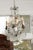 A French six-light crystal chandelier from the 19th century, with pendeloques and patinated metal armature. Created in...