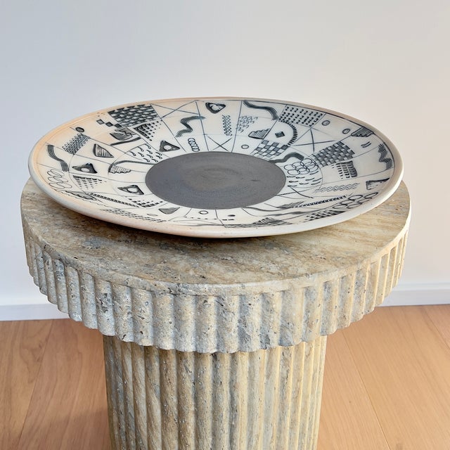 A large-scale stoneware charger by Bob and Cheryl Husby (1948-2025). The piece features a high-contrast monochromatic...