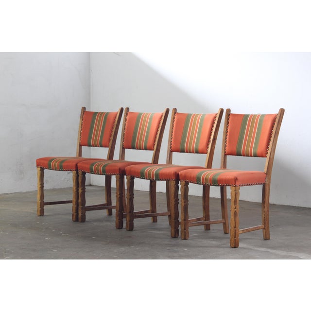 Four vintage Danish dining chairs, crafted in the 1960s-1970s in the style of designer Henning Kjærnulf. These chairs...