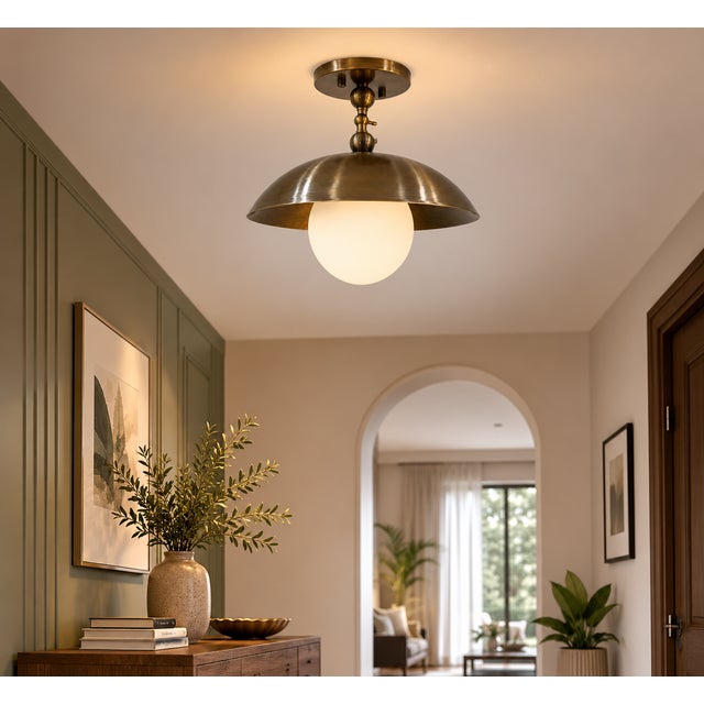 Crafted from solid brass, this pendant light features a gracefully curved dome shade paired with a softly illuminated opal...
