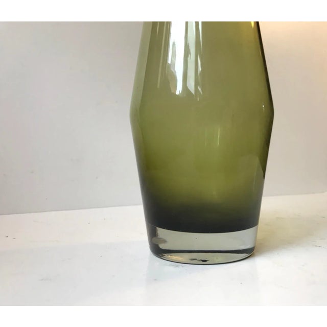 This olive green vase in smoked glass was designed by Tamara Aladin circa 1970 and manufactured by Riihimaen Lasi in...