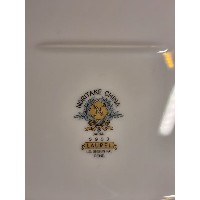 An elegant example of mid-century Noritake craftsmanship, this oval porcelain bread platter features the refined and...