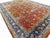 Vintage hand-knotted Persian rug with vibrant rust field adorned with detailed floral and vine motifs, framed by a...