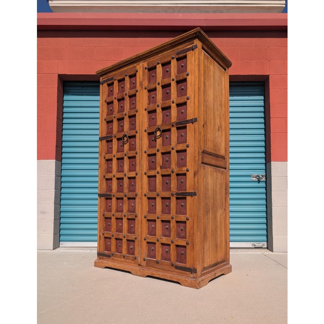 A substantial vintage Mexican solid wood armoire featuring exceptional architectural character and handcrafted detailing....