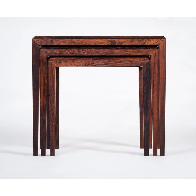 A Danish midcentury nest of three tables made in rosewood and designed by Johannes Andersen for Silkeborg. Minimalistic...
