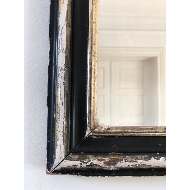 Antique French Louis Philippe mirror, dating to the late 19th century. The mercury glass mirror features a black-painted...