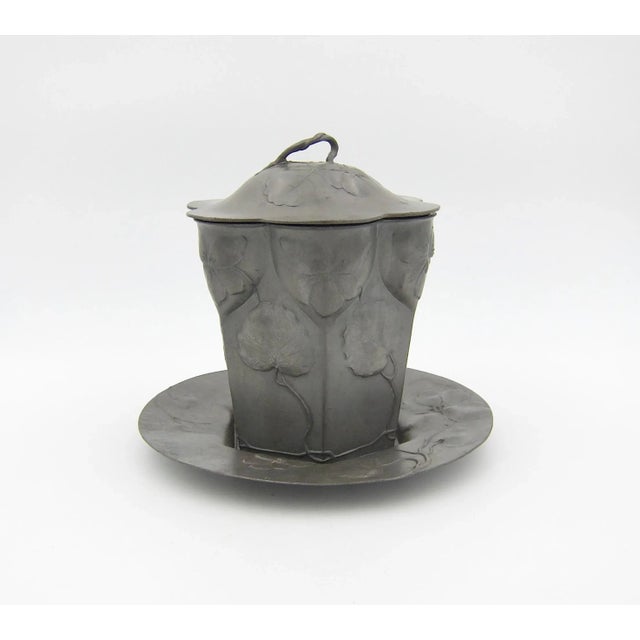 A European covered vessel of pewter in an hexagonal shape with a matching round under-plate, made by Orivit of Cologne in...