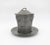 A European covered vessel of pewter in an hexagonal shape with a matching round under-plate, made by Orivit of Cologne in...
