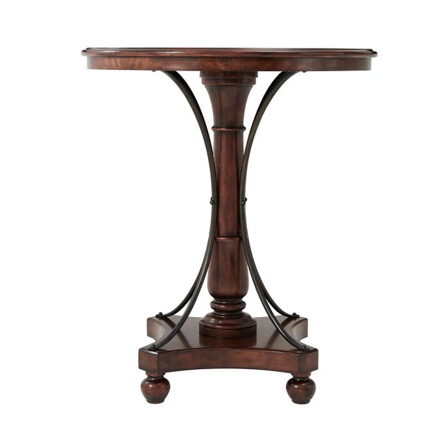 A French-style mahogany bar table, the circular crossbanded molded edge top above a ring turned column support with...