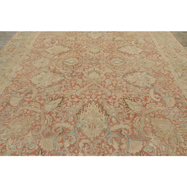 Handwoven in wool, this oversized antique 11x15 Persian Tabriz rug dates to circa 1920–1930. The distressed piece features...